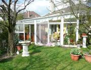 T38, Ötszög alaprajzú télikert üvegtetővel kívülről beleolvadva a tavaszi kertbe
